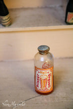 Afbeelding in Gallery-weergave laden, Oude glazen flesjes  voor in een speelgoedwinkeltje.
